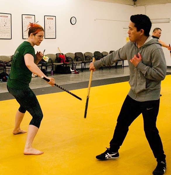 Large group of students practice filipino eskrima arnis stick